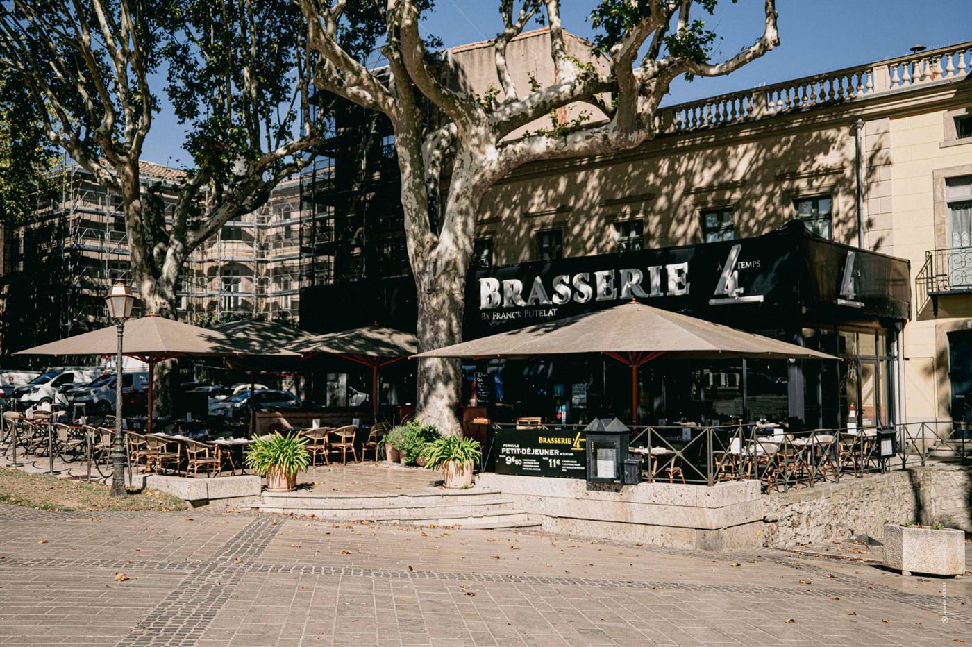 La façade de la brasserie et sa terrasse sous les platanes, boulevard Barbès